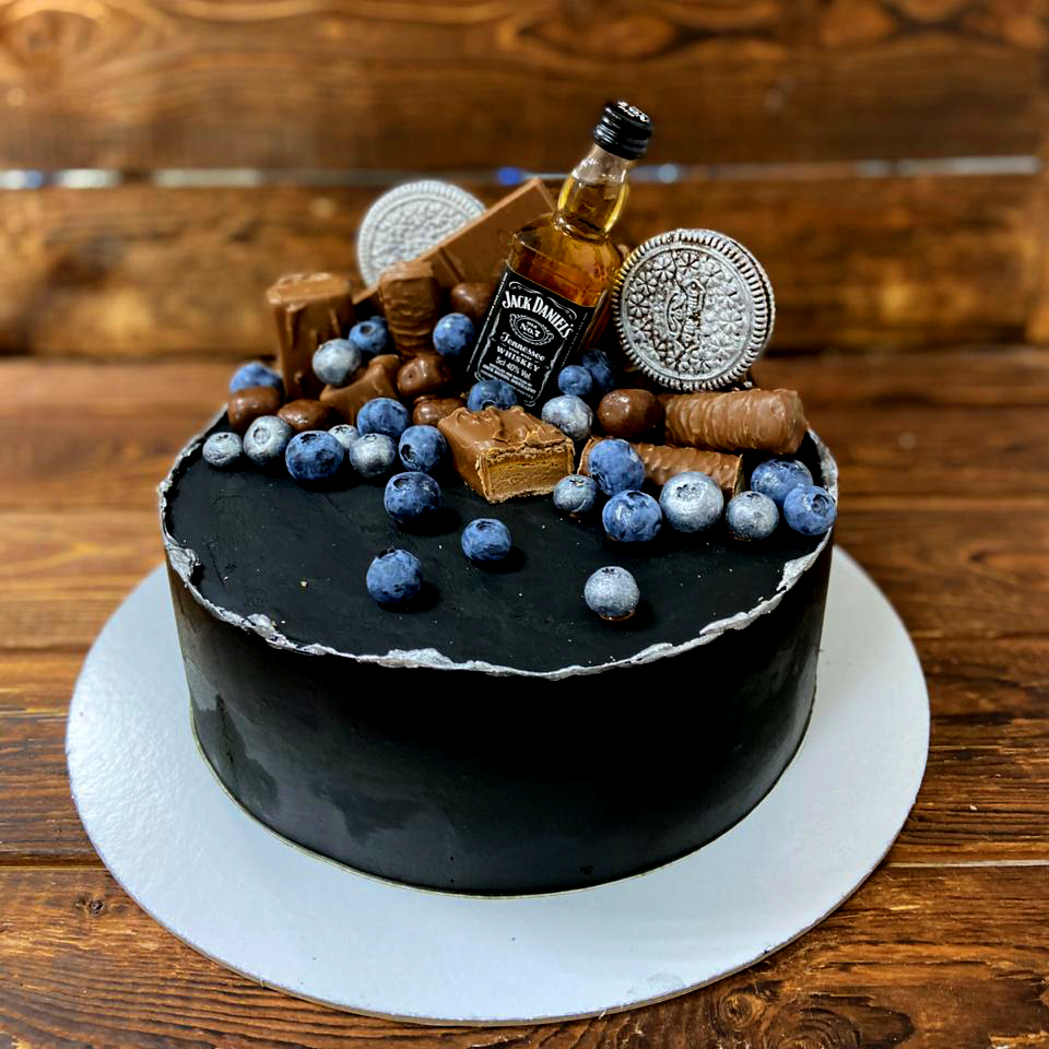 Торт для мужчины с кремовым покрытием черного цвета, бутылочкой виски и  ягодами